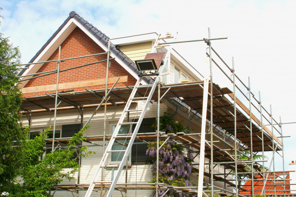 Exterior home renovation with scaffolding and construction equipment