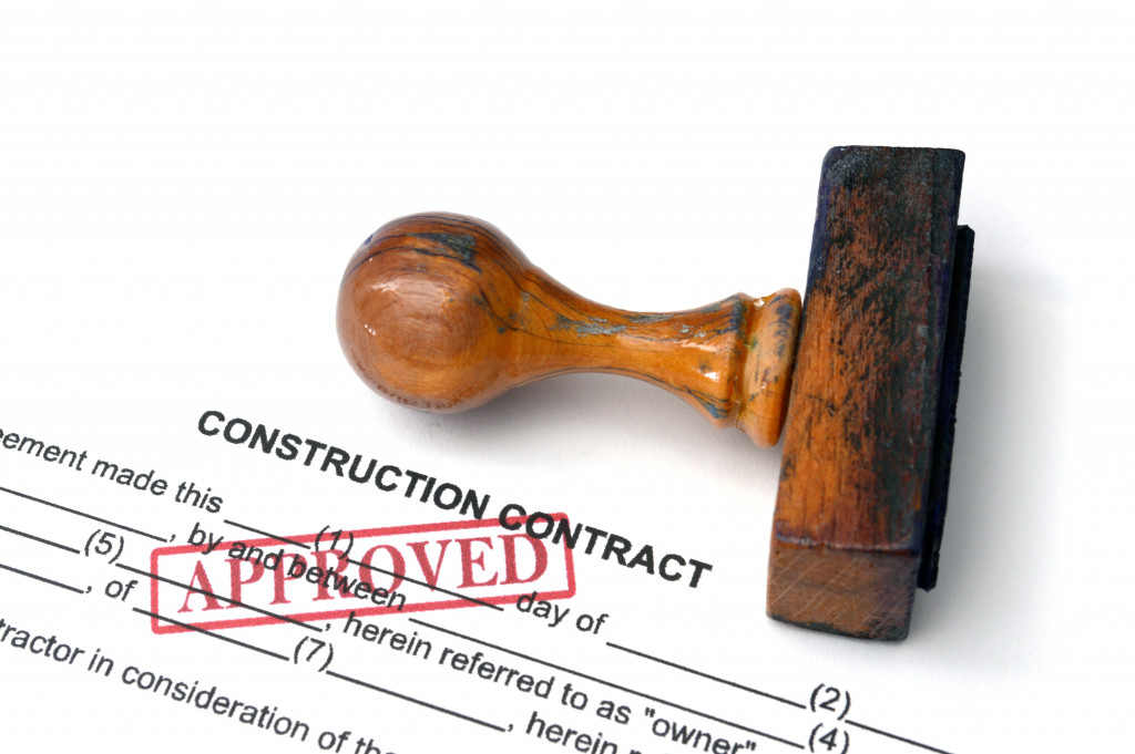 An approved construction contract with a wooden stamp