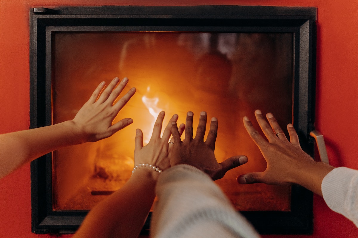 couple getting warm in the fireplace