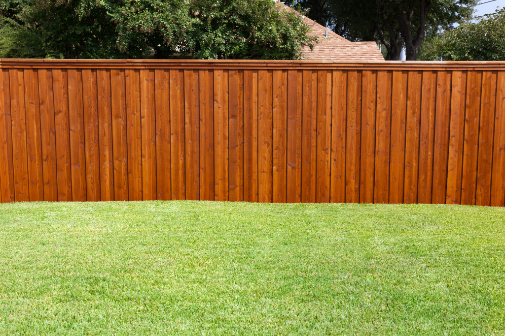 A wood fence on a lawn