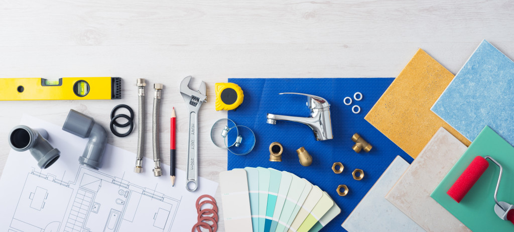 tools and plans for a kitchen or bathroom remodel laid out in the tiled floor