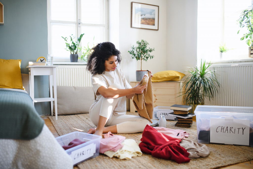 young woman decluttering her room with boxes for charity