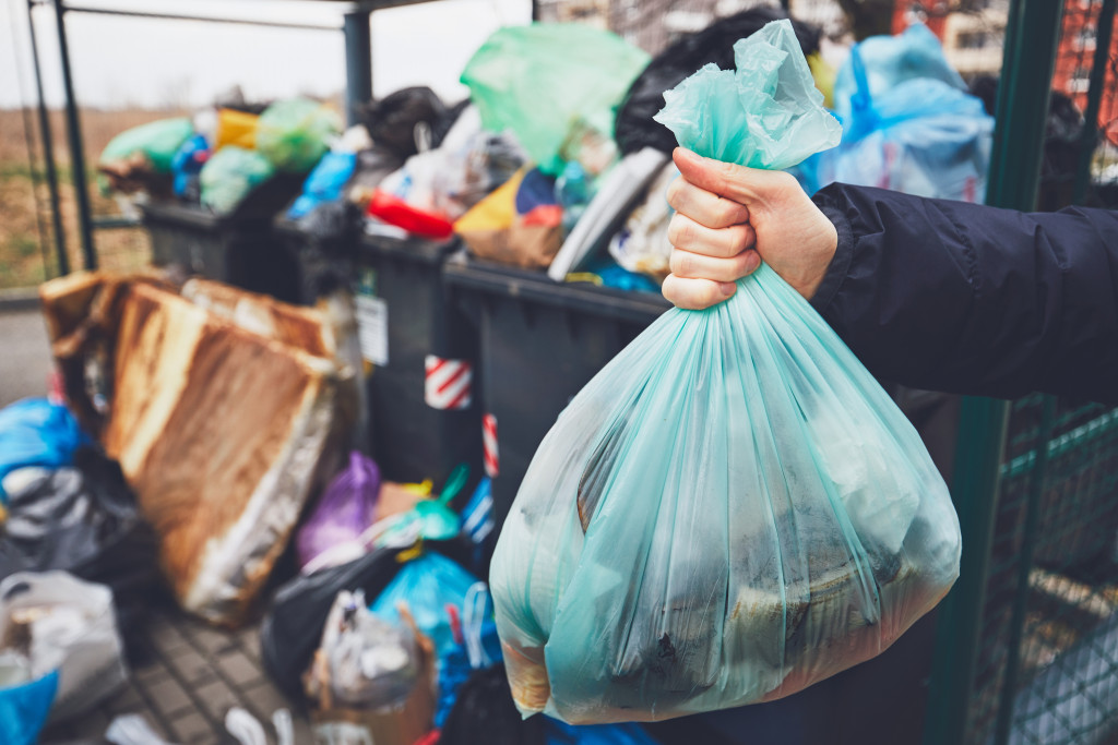 a hand holding a bag of trash